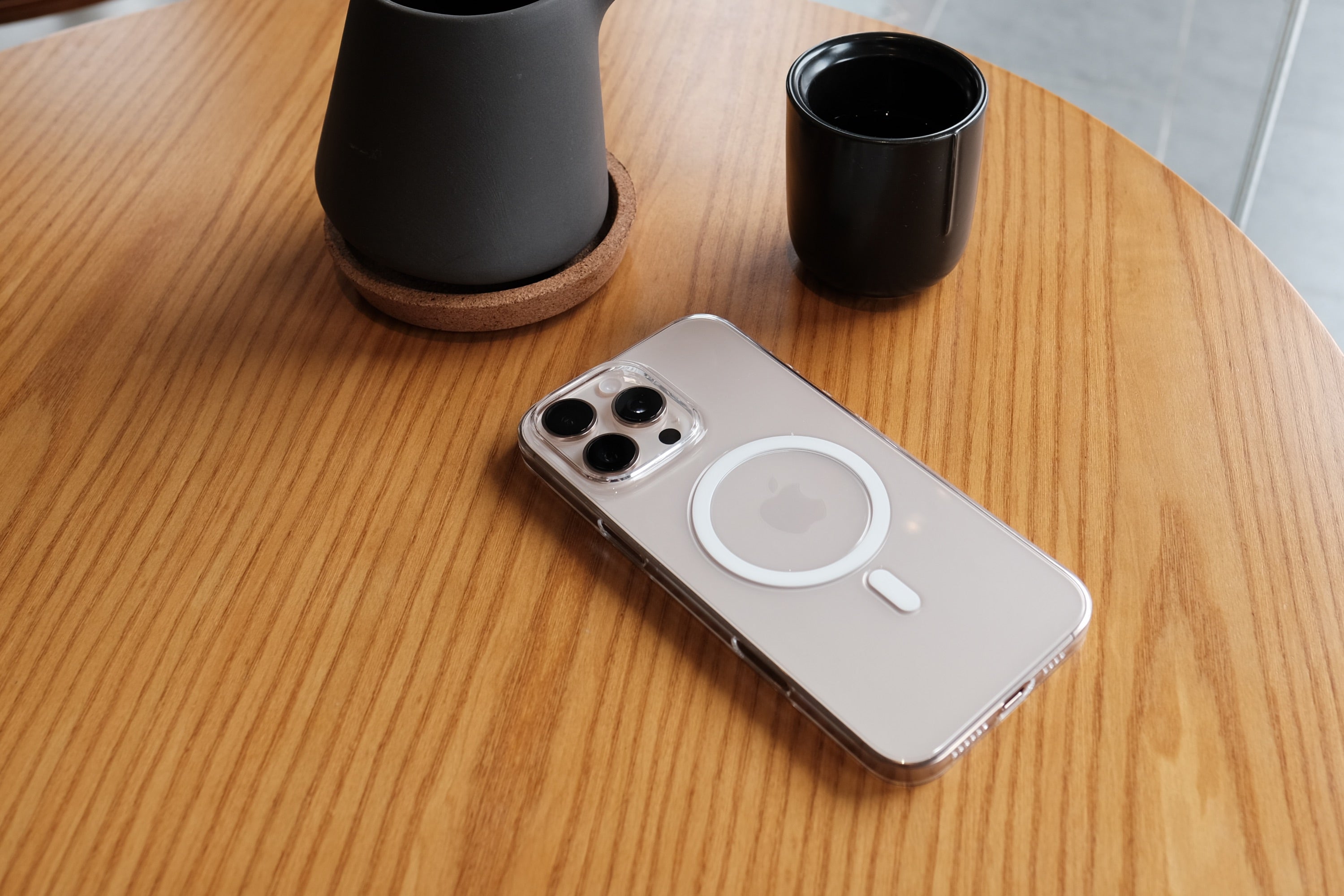 The Bare Case - Thinnest Clear MagSafe Case for iPhone 16 Series - Desert Titanium - on Table - Banner - 2